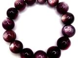 a close up of a bracelet made of purple marble beads