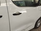 a white van parked in a parking lot with its door open