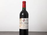une bouteille de vin rouge posée sur une table en bois