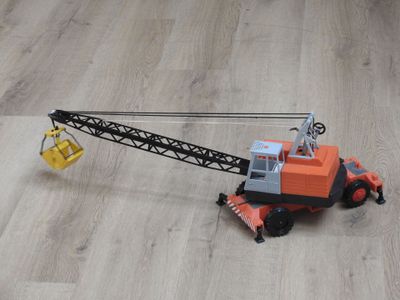 une petite grue en jouet posée par terre