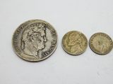 a close up of three coins on a white surface