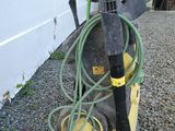 un tuyau vert raccordé à une machine noire et jaune