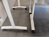a white table with wheels on it in a room