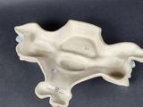 an image of a white ceramic object on a black surface
