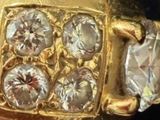 an image of a close up of a person ' s hand holding a gold ring with three diamonds
