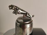 a silver statue of a cat on top of a silver object