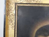 portrait of a man with a beard in a gold frame on a white wall