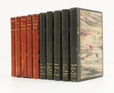 plusieurs vieux livres sont alignés sur une surface blanche