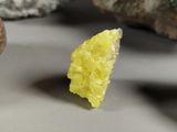 a small piece of yellow rock next to some rocks