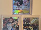 Trois cartes Pokémon différentes sont exposées sur un mur.