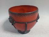 a red and black bowl sitting on top of a white table