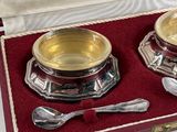 two silver bowls and spoons in a red box