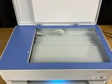 an open white and blue printer sitting on top of a wooden table