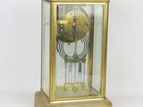a gold clock with a glass case on top of it