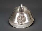 a silver helmet with a coin on top of it