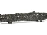 bronze figurine of a fish on a wooden stand on a white background