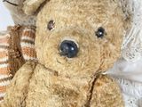 two teddy bears sitting next to each other on a bed