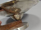 a person holding a wooden spoon in a silver bowl