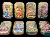 pokemon tins are lined up in a row on a black background