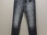 a pair of jeans hanging on a hanger against a wall
