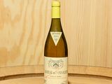 une bouteille de vin posée sur un tonneau
