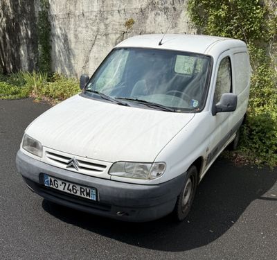 une petite camionnette blanche garée sur le bord de la route