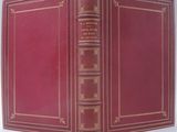 un livre rouge ouvert sur une surface blanche
