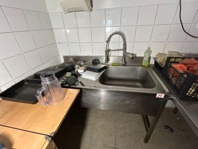 un évier en acier inoxydable dans une cuisine dotée d'un plan de travail en bois