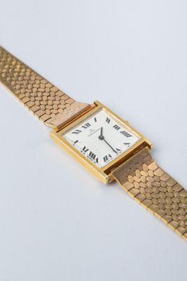 une image d'une montre-bracelet en or avec des chiffres romains