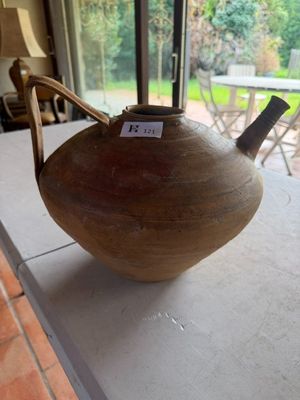 une théière posée sur une table devant une fenêtre