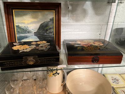 une vitrine en verre sur laquelle sont posés un tableau et un bol