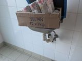 une boîte de papier toilette posée par terre à côté d'une poubelle