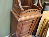 a grandfather clock that is sitting on the floor next to a mirror