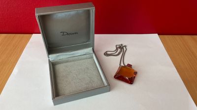 une boîte ouverte contenant une paire de boucles d'oreilles, posée sur une table