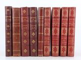 plusieurs vieux livres sont alignés sur une surface blanche
