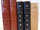 several books are lined up in a row on a white surface