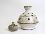 two vases sitting next to each other on a white surface