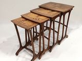 un ensemble de trois tables gigognes en bois sur fond blanc