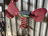 un moulin à vent rouge et vert posé sur un support métallique