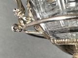 a silver plate with a glass bowl on top of it
