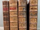 Quatre vieux livres sont alignés sur une table