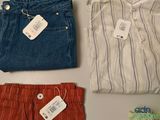 three pairs of men ' s shirts and pants with price tags on them