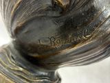bronze statue of a rooster on a red base with a white background