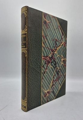 un vieux livre à la couverture verte et aux bordures dorées