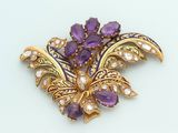 an image of a brooch with purple and white stones on a white surface
