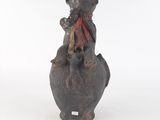 une petite statue représentant un singe avec un foulard rouge autour du cou