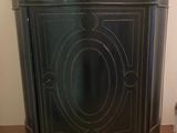 a black cabinet with a marble top on a wooden floor