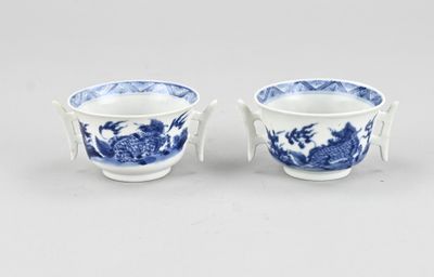 une paire de tasses bleues et blanches ornées d'anses en forme de dragon