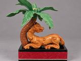 une figurine représentant un lion sous un palmier