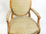 une image représentant une chaise dont le dossier et les accoudoirs sont recouverts d'un tissu beige
